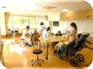 介護施設の共用スペースで入居者と職員がレクリエーション活動を行っている風景